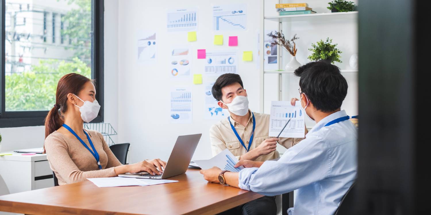 office employees collaborating with safe management measures at the workplace